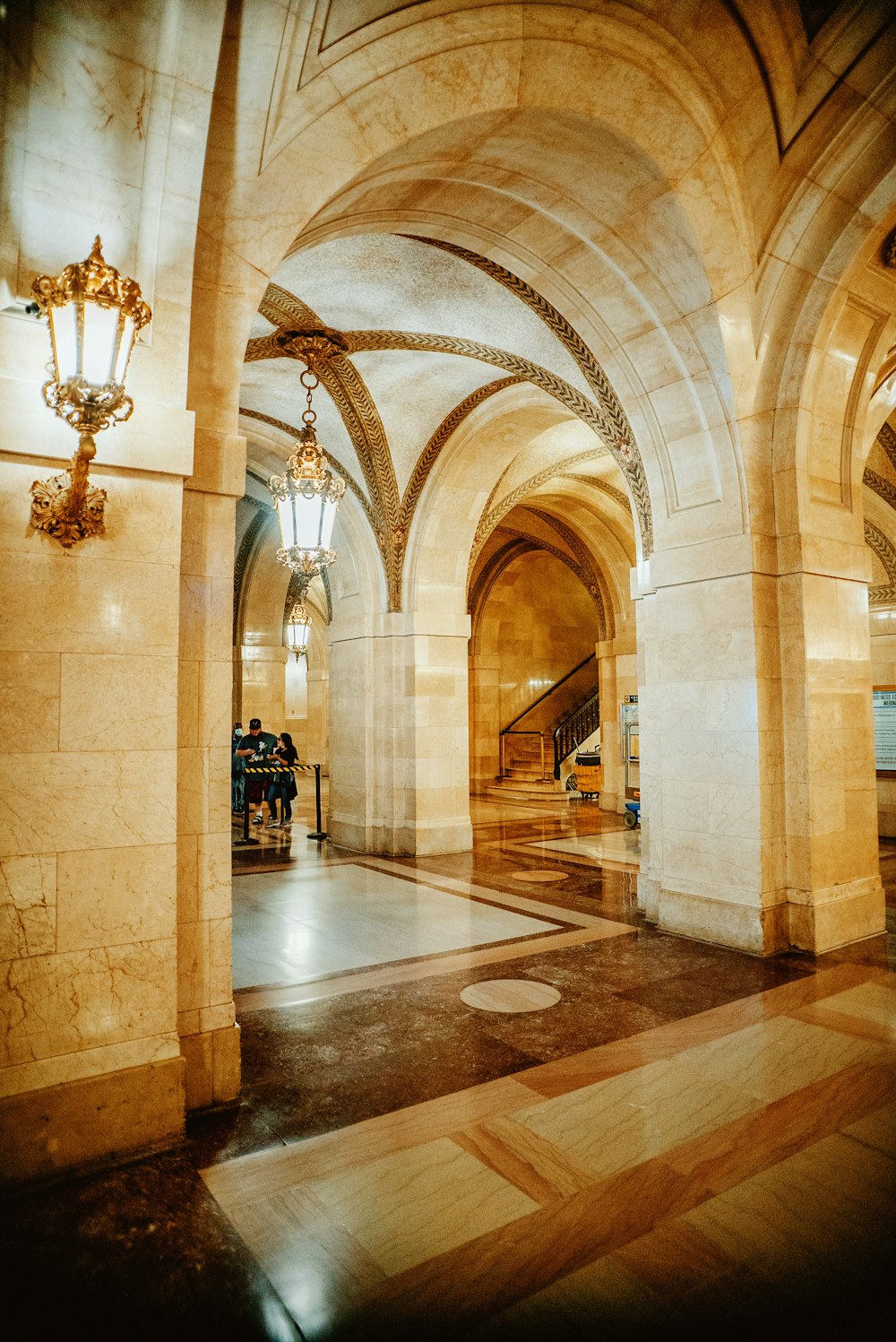 a large hallway with a chandelier and a couple people