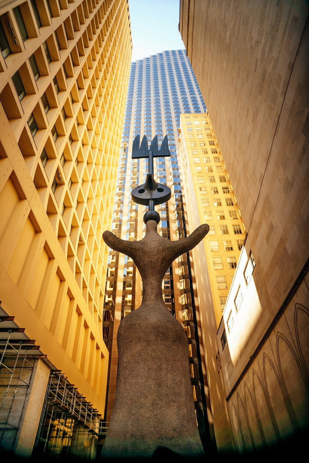 a statue in between tall buildings