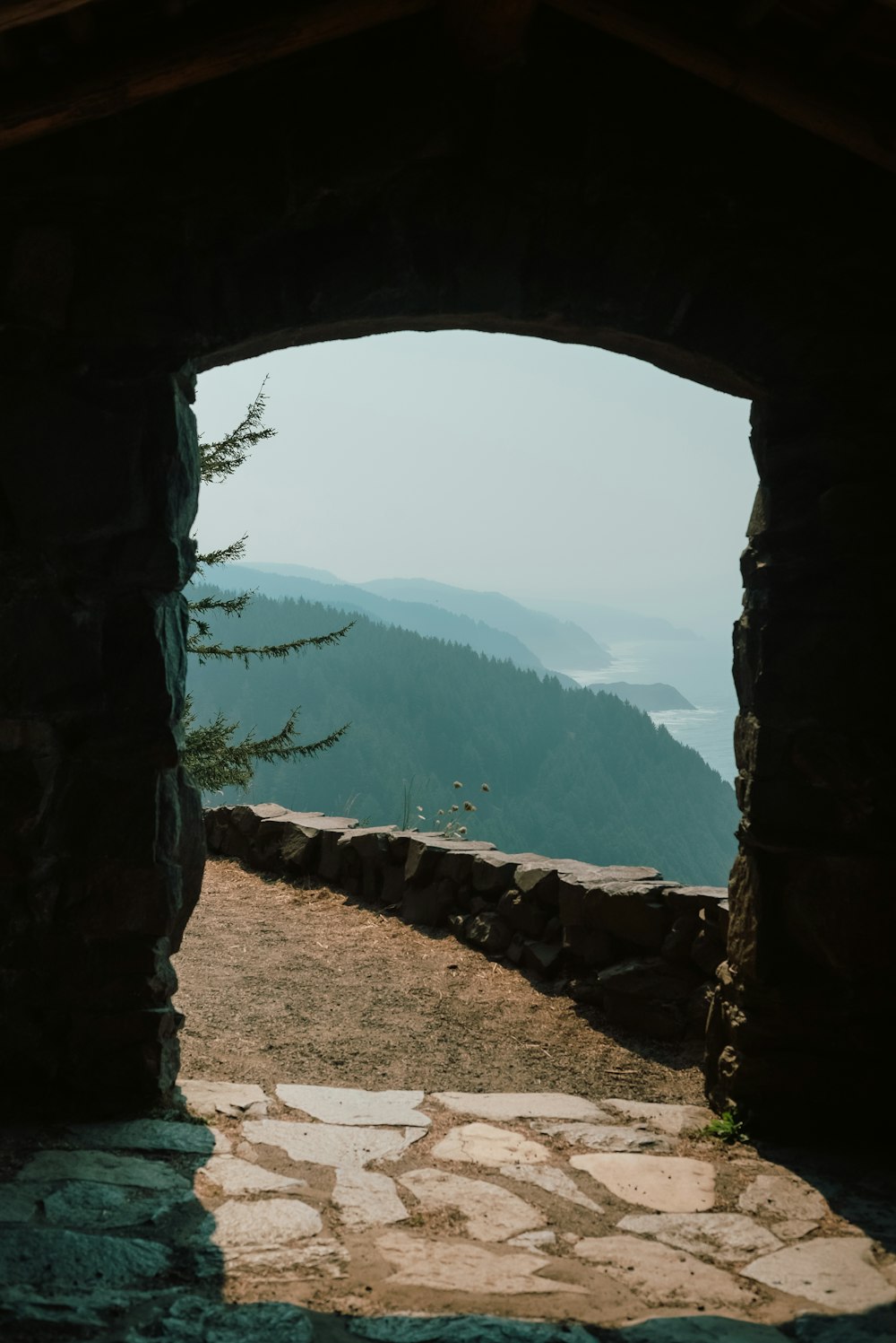 a view of the ocean through a stone archway