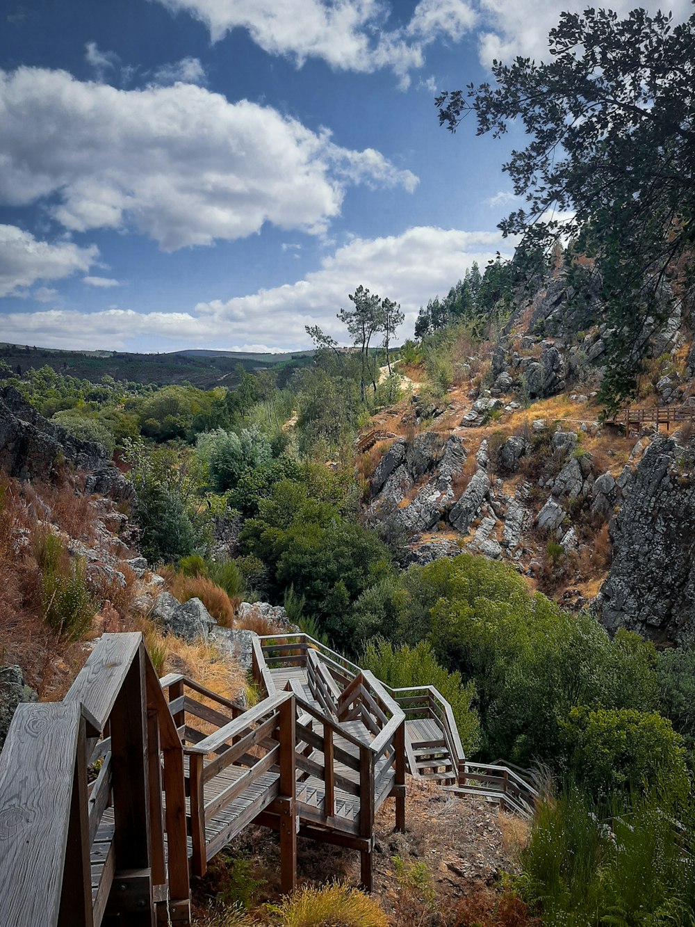 a wooden bridge over a rocky hillside