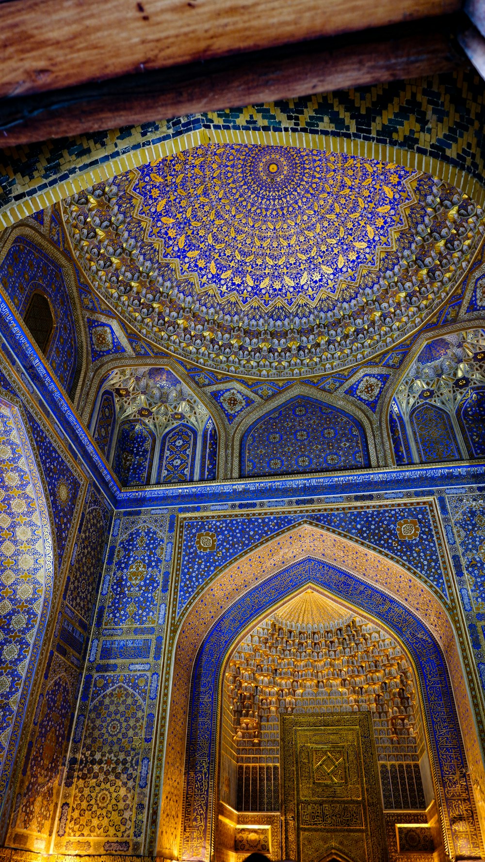 a colorful ceiling with a large arched window with Dome of the Rock in the background