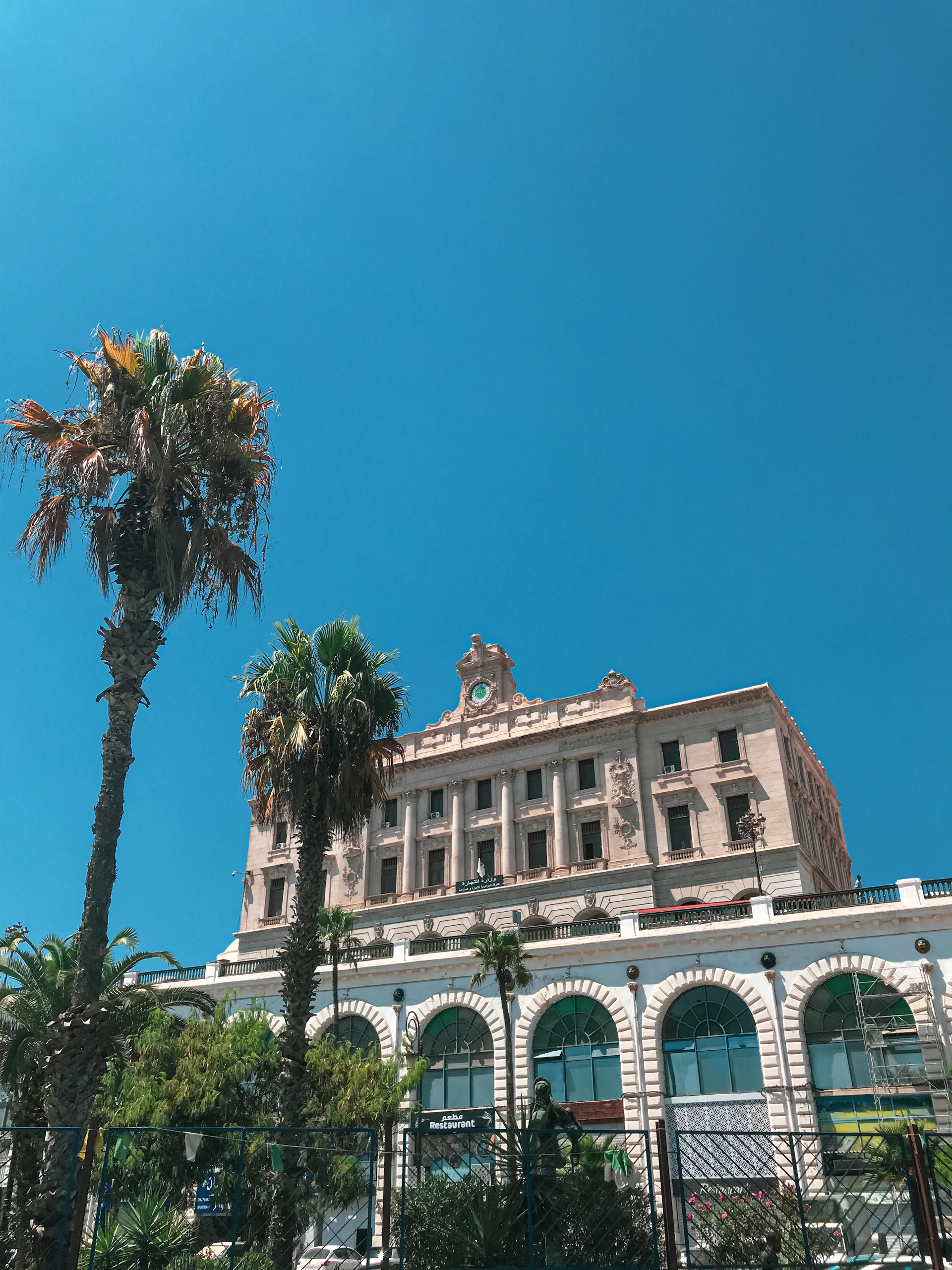 a large building with palm trees in front of it