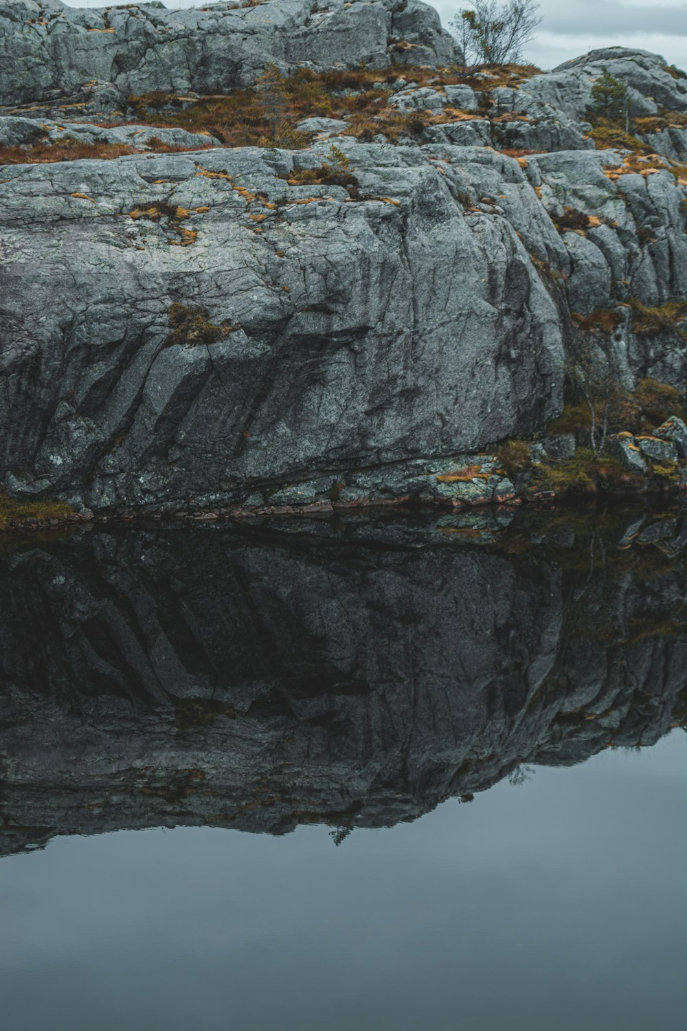 a rocky cliff with a body of water below