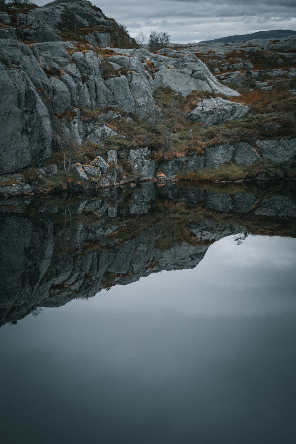 a rocky cliff with a body of water below