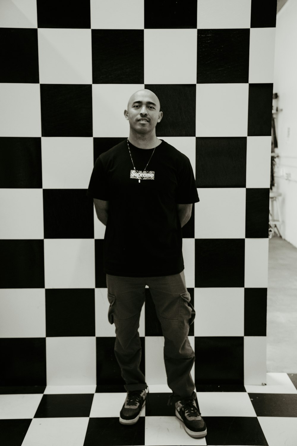a man standing in front of a black and white checkered wall