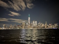 A night shot of a city skyline illuminated partly by clean energy solutions from Ecotrust Global.