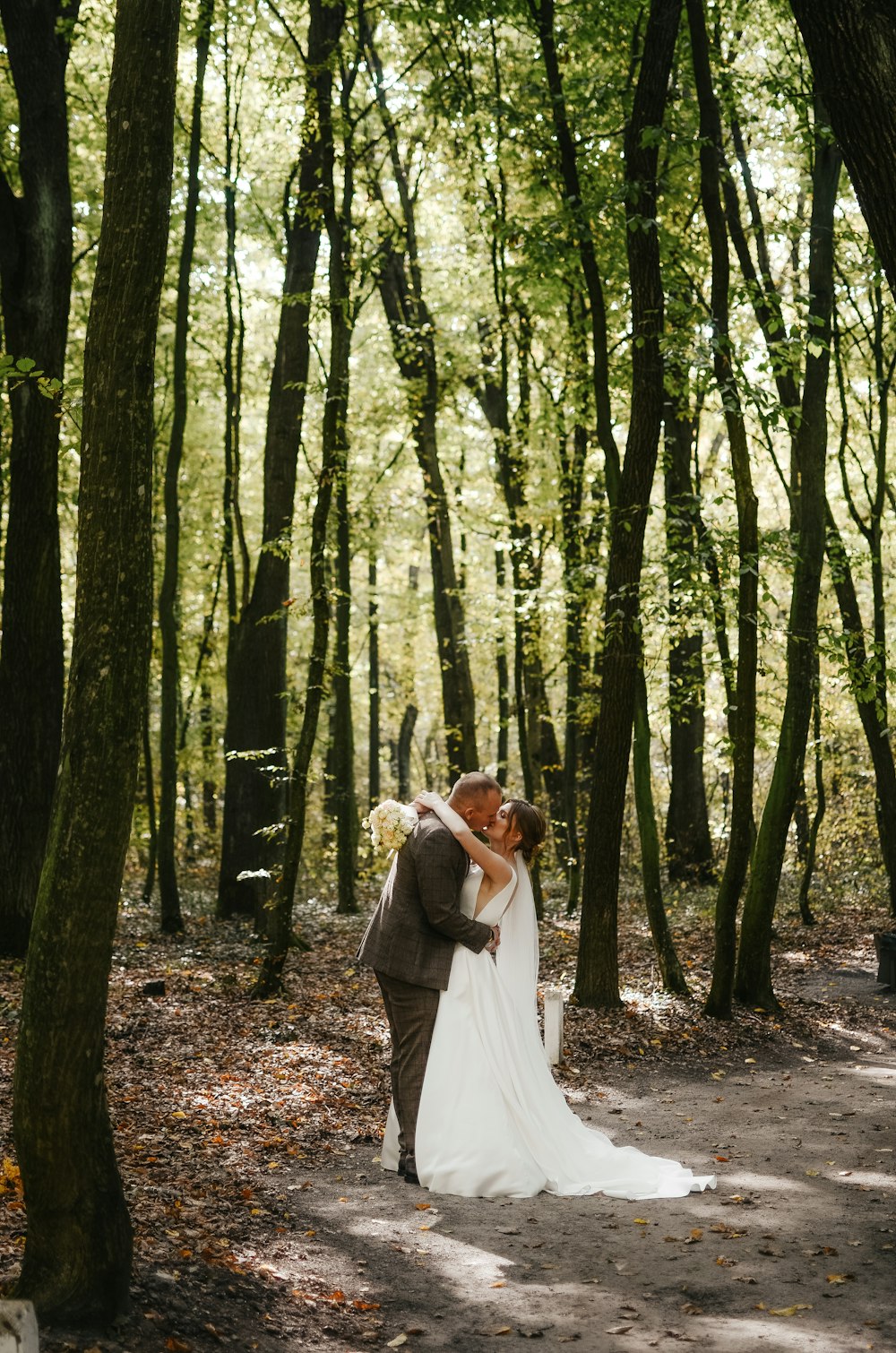 a man and woman kissing in a forest