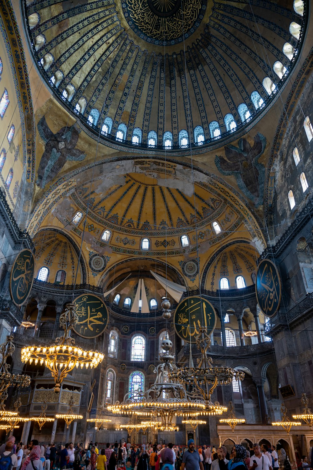 a large ornate ceiling with many people with Hagia Sophia in the background