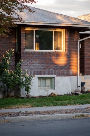 A freshly cleaned brick house exterior gleaming under the morning sun, showcasing spotless siding and vibrant colors.