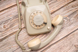 a white telephone on a wooden surface