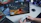 Excited gamer watching GTA 6 trailer leaks on a laptop in a dark room with neon blue and purple lights
