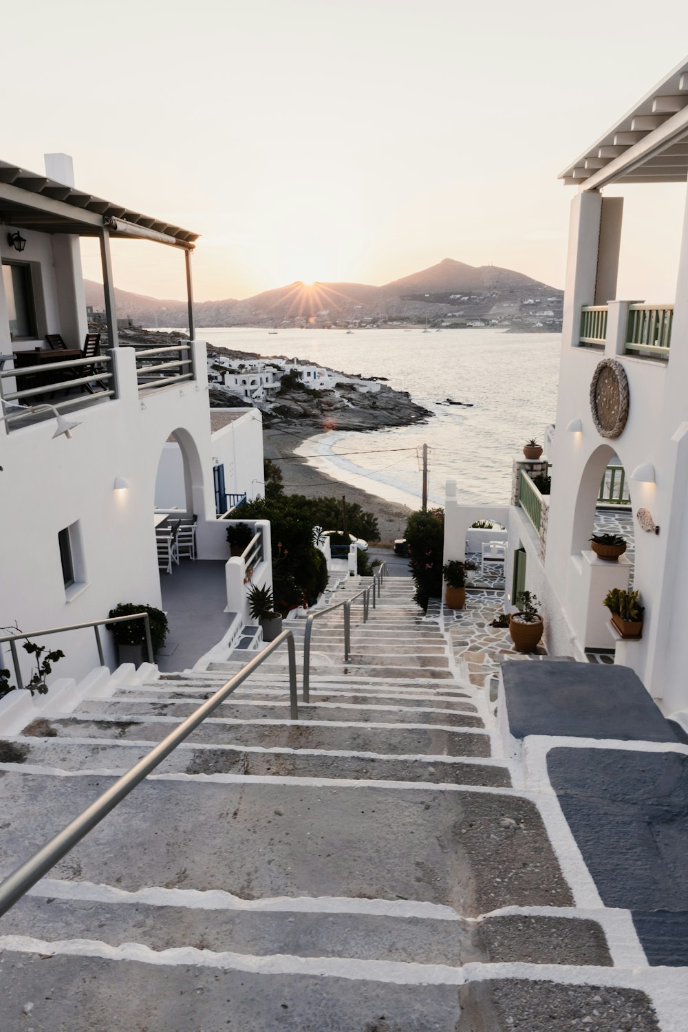 a courtyard with buildings and a body of water in the background