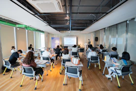 a group of people sitting in a room with computers