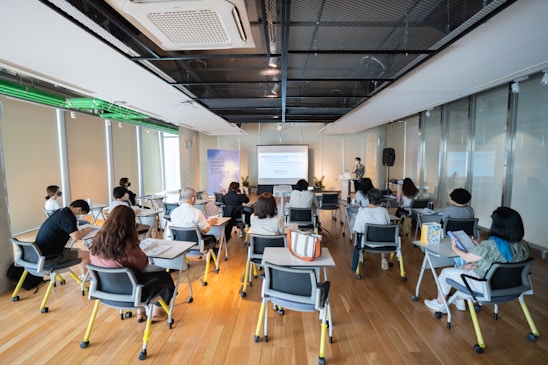 a group of people sitting in a room with computers