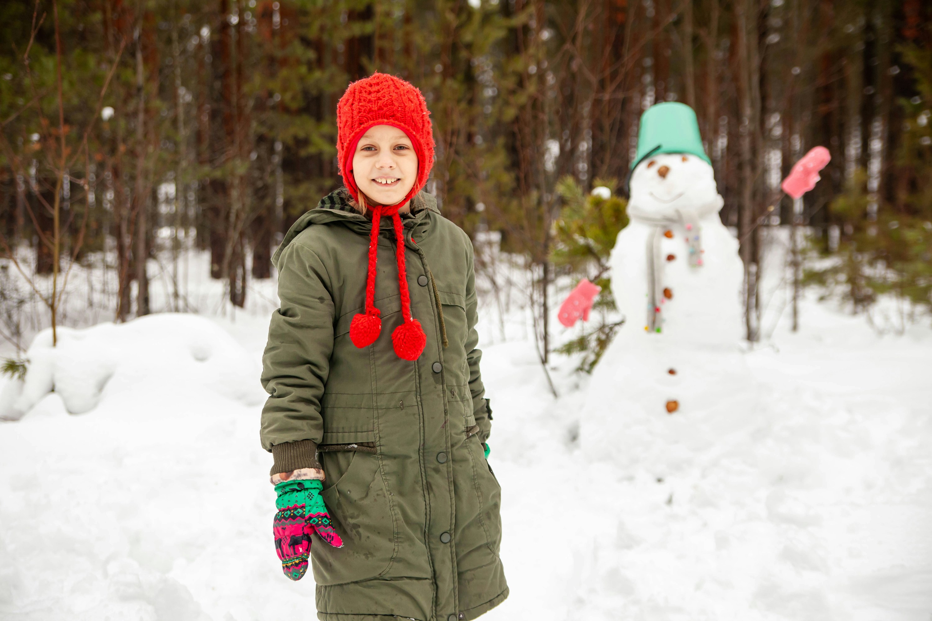 겨울철 학생 패션 트렌드 - a boy standing next to a snowman