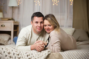 a man and woman sitting on a bed