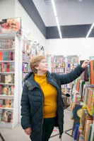 Close-up of a hand picking a well-loved book from the pagenest store’s featured picks.