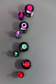 Close-up of glossy nail polish bottles arranged in a colorful row.