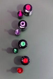 Nail polish bottles in various shades lined up on a bright surface with manicure tools.