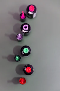 Close-up of vibrant nail polish bottles arranged in a colorful gradient.