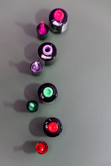 Close-up of vibrant nail polish bottles arranged in a colorful gradient.
