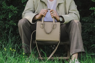 a person sitting on a bench holding a purse