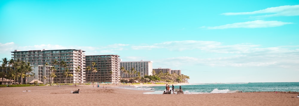 a beach with people and buildings in the background