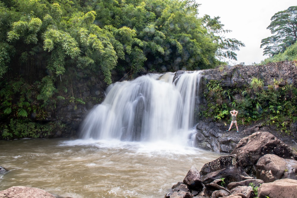 a person standing next to a waterfall