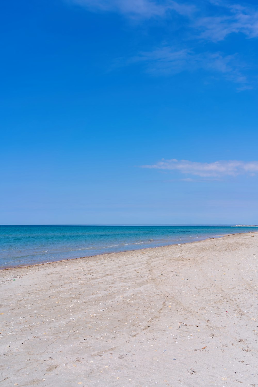 uma praia de areia com água azul