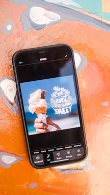 A cheerful hand holding a phone displaying colorful dessert photos ready to order.