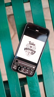 a black rectangular device with a white label on a green surface