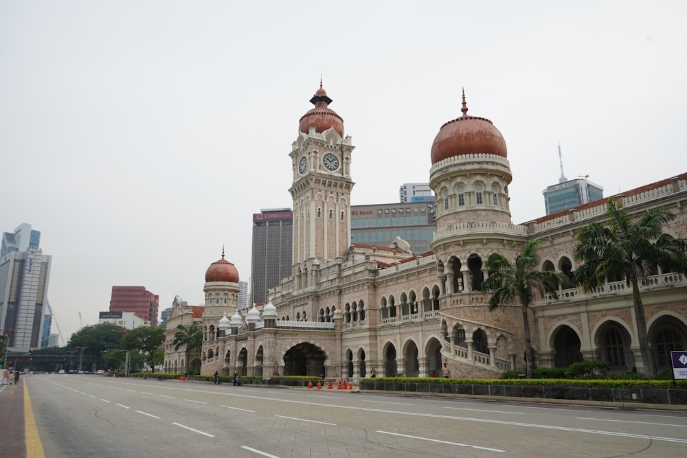 ein großes Gebäude mit einem Glockenturm mit Merdeka Square, Kuala Lumpur im Hintergrund