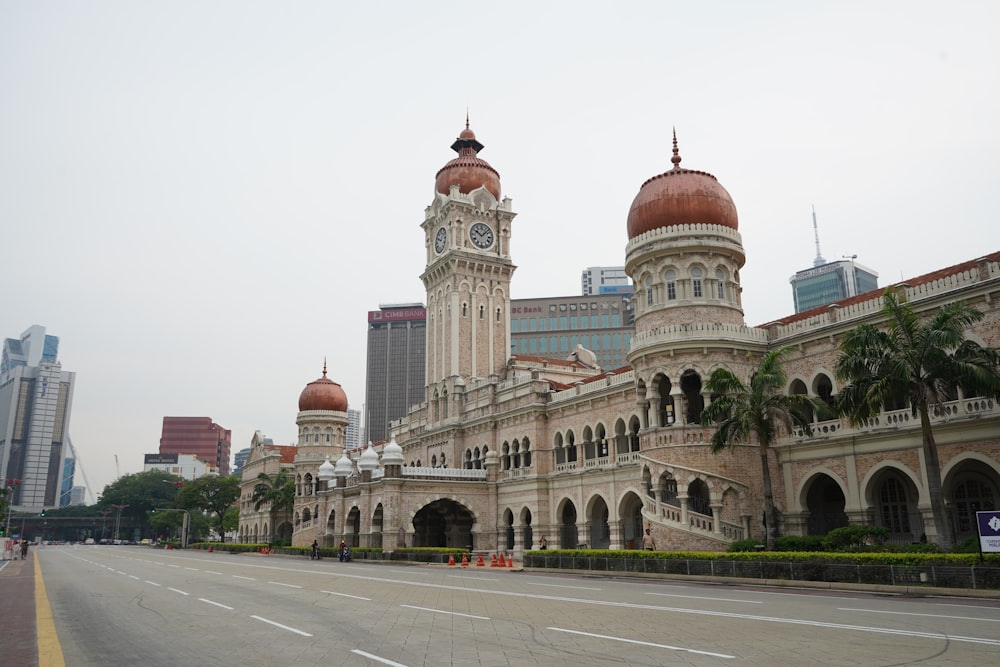 un grande edificio con una torre dell'orologio con Merdeka Square, Kuala Lumpur sullo sfondo