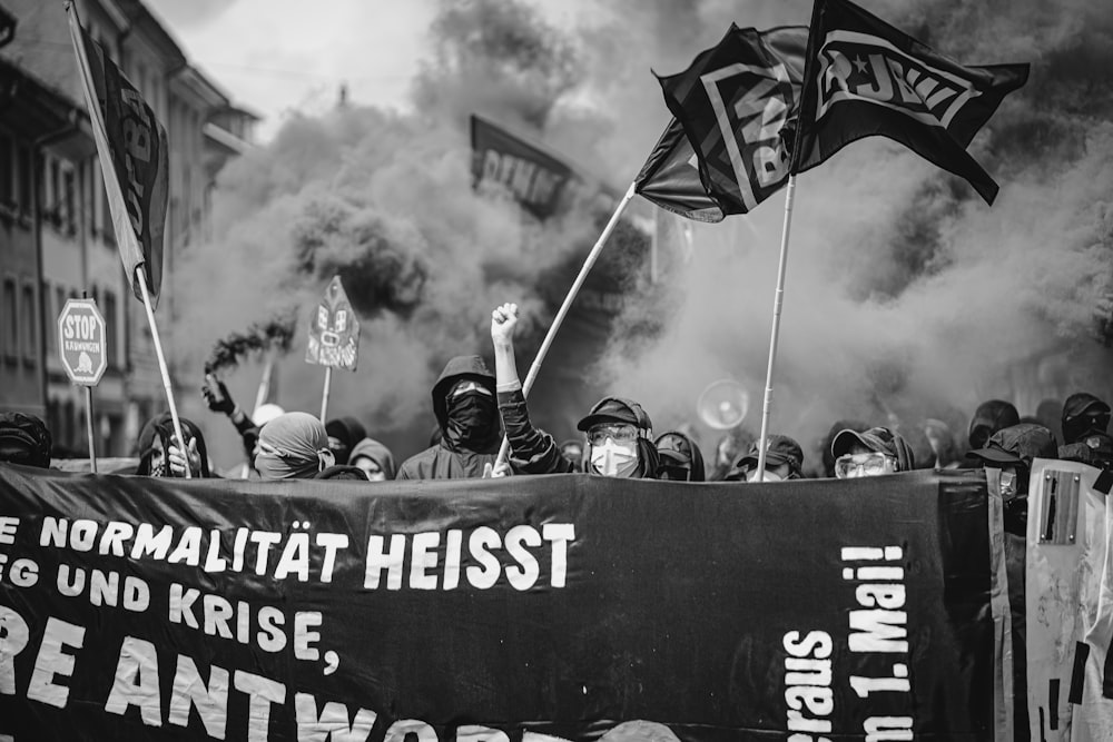 a group of people holding flags and signs