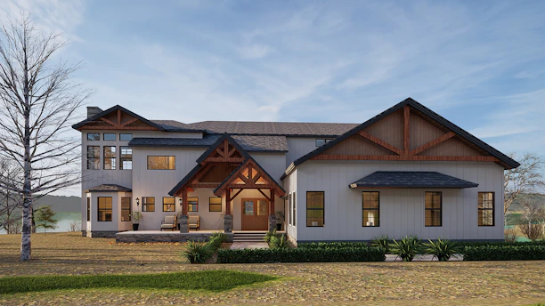 An elegant exterior shot of a custom home showcasing a blend of stone and wood finishes under a clear blue sky.