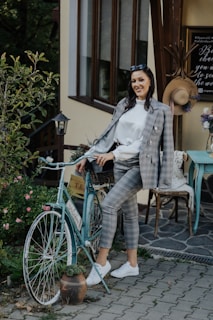 Chantal smiling next to her bike in a quaint French village.