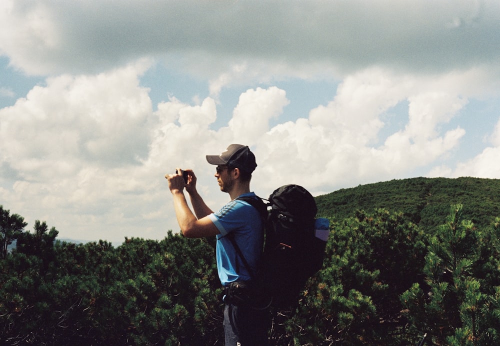 a man with a backpack looking at a phone