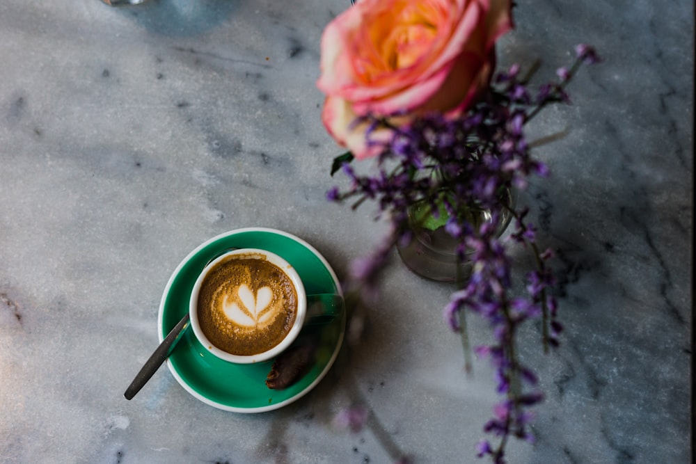 a cup of tea next to a bouquet of flowers