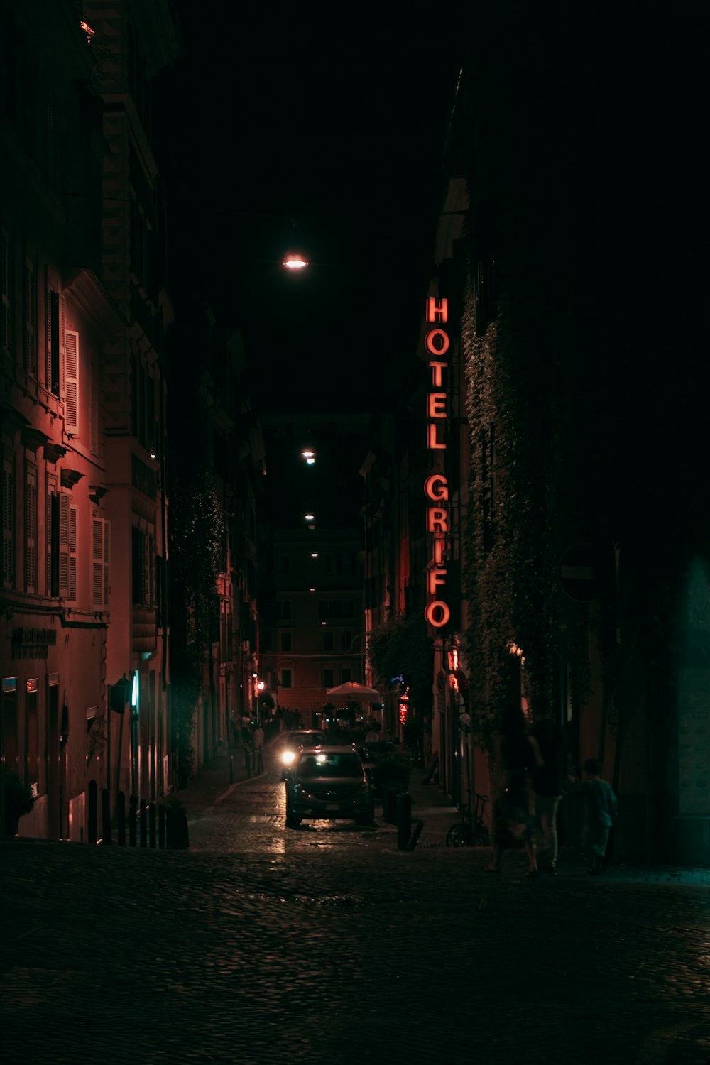 a street with cars and buildings at night