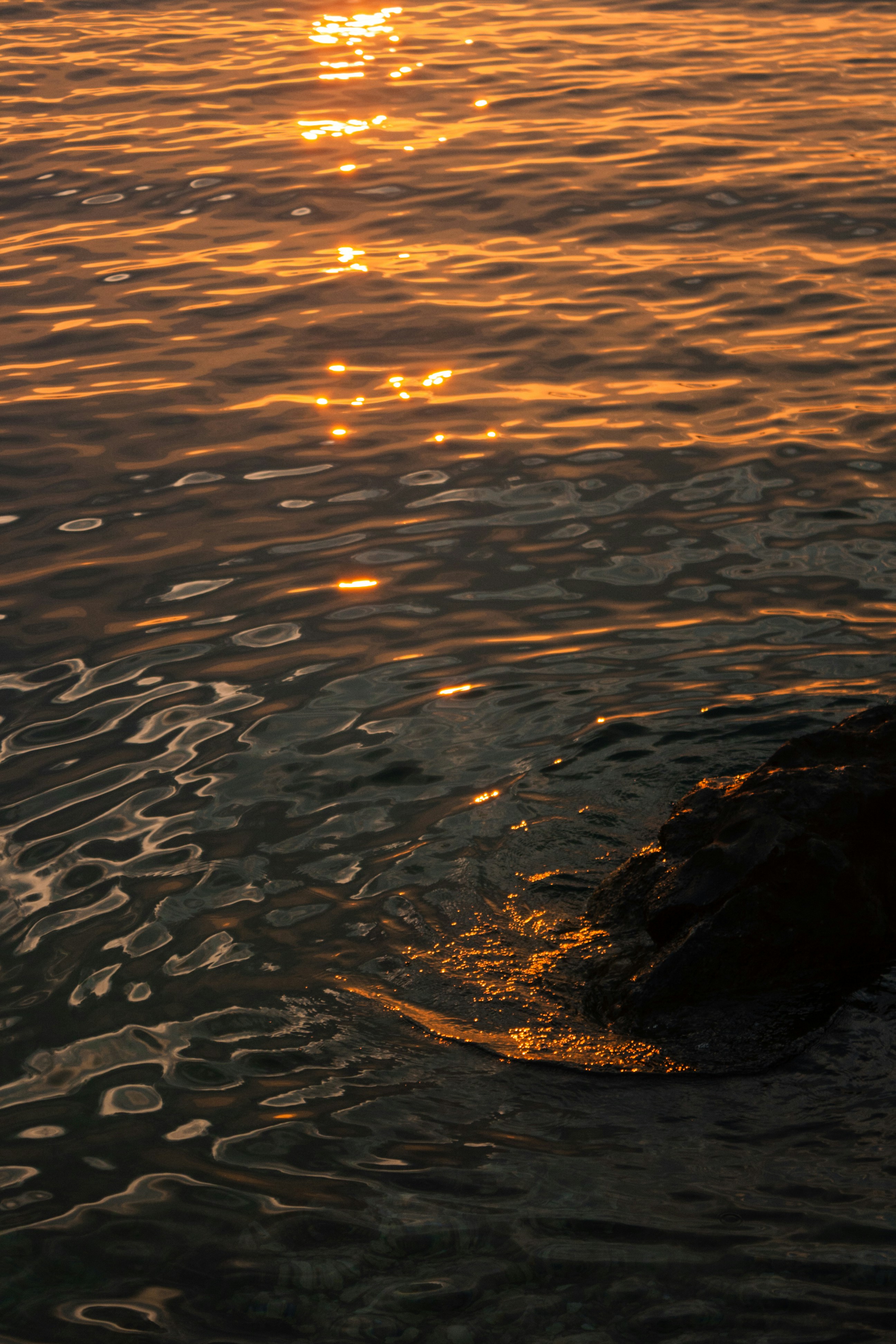 a body of water with a rock in it and a rock in the foreground