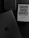 A book with the title 'Damn Good Advice (for people with talent!)' by George Lois is placed on a dark surface alongside a keyboard and an open laptop displaying the Apple logo. The overall color scheme is monochromatic, dominated by dark shades, enhancing a professional ambiance.