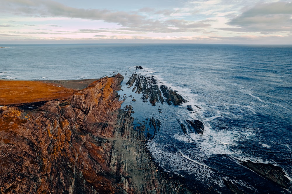 a rocky cliff next to the ocean