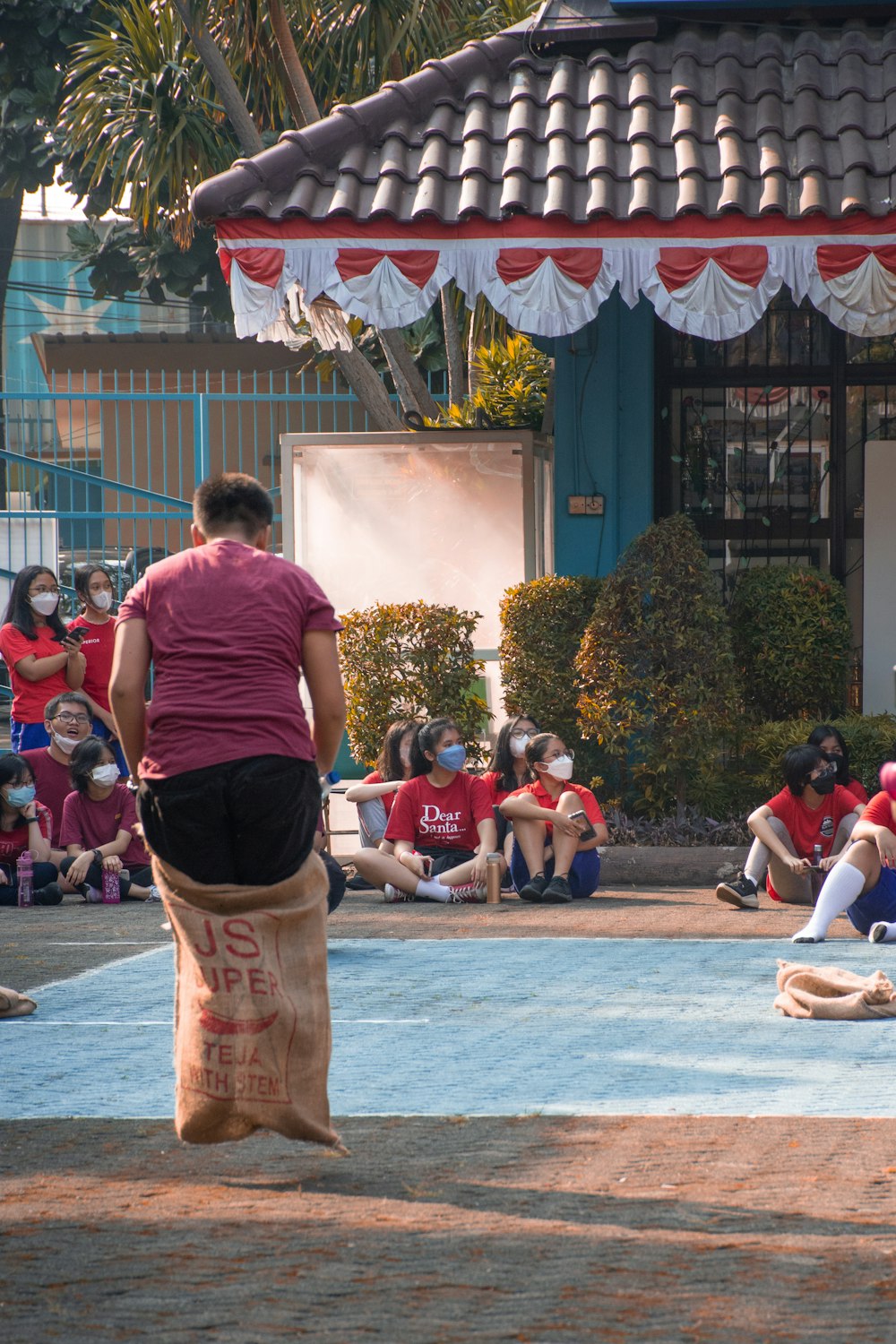 a person standing in front of a pool with people sitting on the side