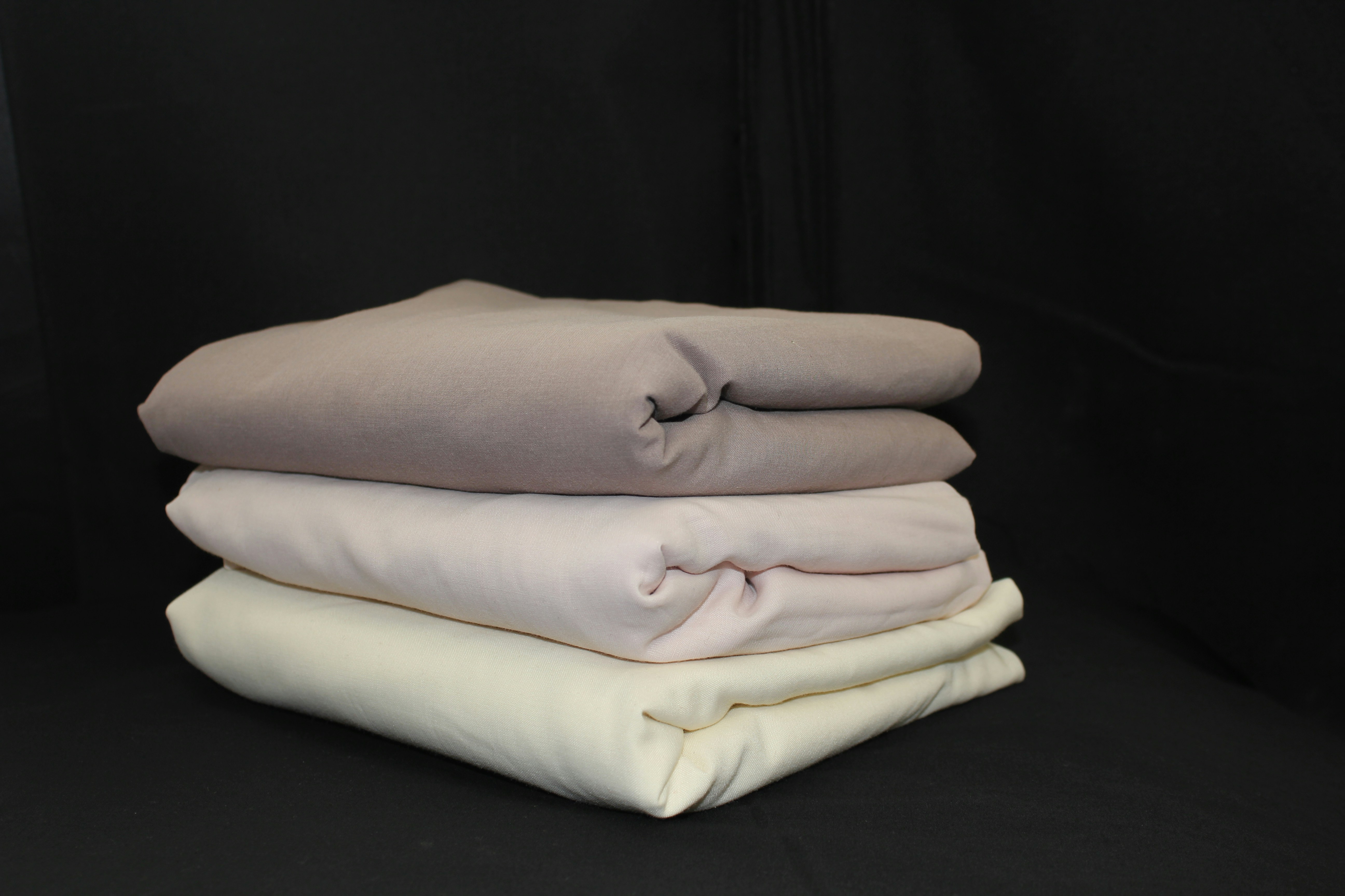 Various sizes of duvet covers neatly folded and labeled
