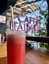 Close-up of a frosty frappé with artisanal garnish on a rustic wooden table.