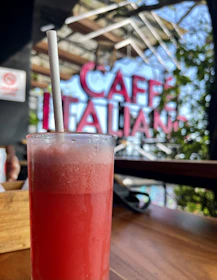 Close-up of a frosty frappé with artisanal garnish on a rustic wooden table.