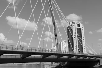 a bridge over water with a city in the background