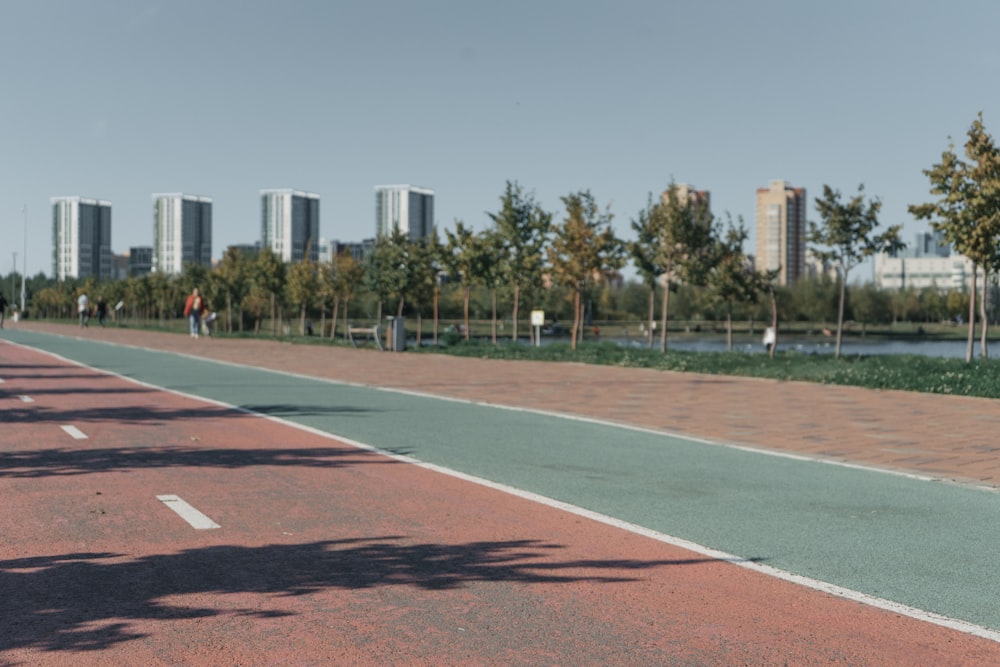 a paved area with trees and buildings in the background