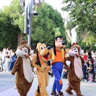 a group of people in clothing walking down a street