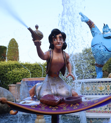 a woman sitting on a fountain with a statue of a man holding a sword